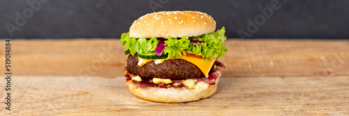 Hamburger Cheeseburger fastfood fast food on a wooden board panorama with copyspace copy space
