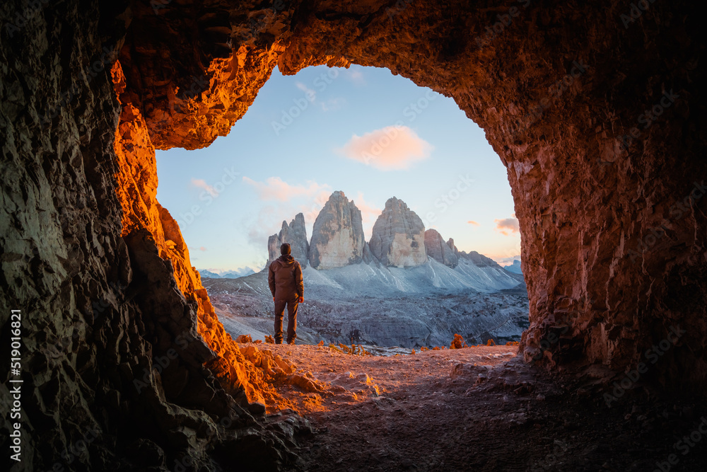 Tre Cime Di Lavaredo peaks in incredible orange sunset light. View from the cave in mountain against Three peaks of Lavaredo, Dolomite Alps, Italy, Europe. Landscape photography - obrazy, fototapety, plakaty 