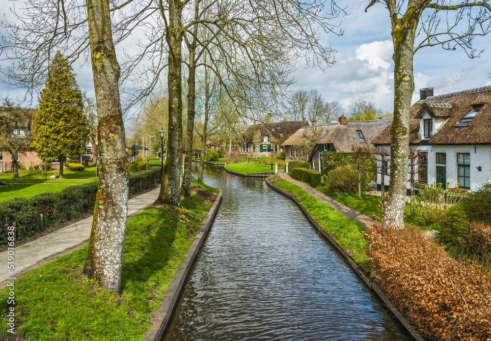 A street with houses on the canal waterfront in Giethoorn village, Netherlands
