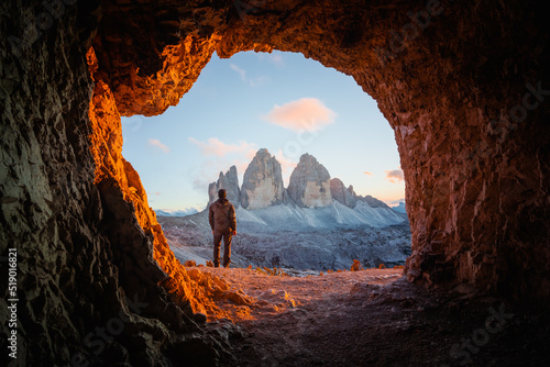 Tre Cime Di Lavaredo peaks in incredible orange sunset light. View from the cave in mountain against Three peaks of Lavaredo, Dolomite Alps, Italy, Europe. Landscape photography photo