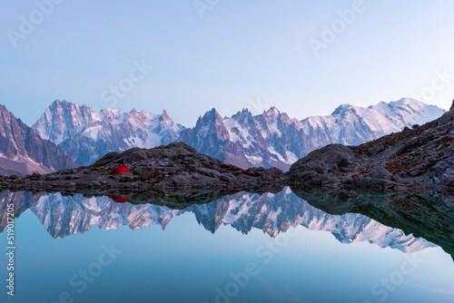 Fotografi Red tent on Lac Blanc lake coast in France Alps