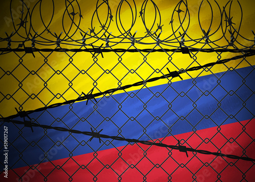 Colombia flag behind barbed wire and metal fence photo