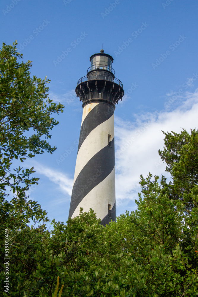 view of Cape Hatteras Lighthouse through the trees on the coast of the Outer Banks