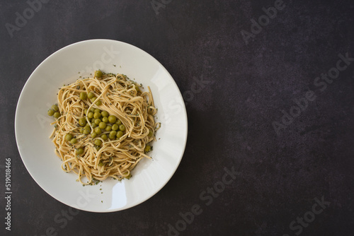Soy noodles with peas. Vegetable protein in legumes.White plate on table with dark background.