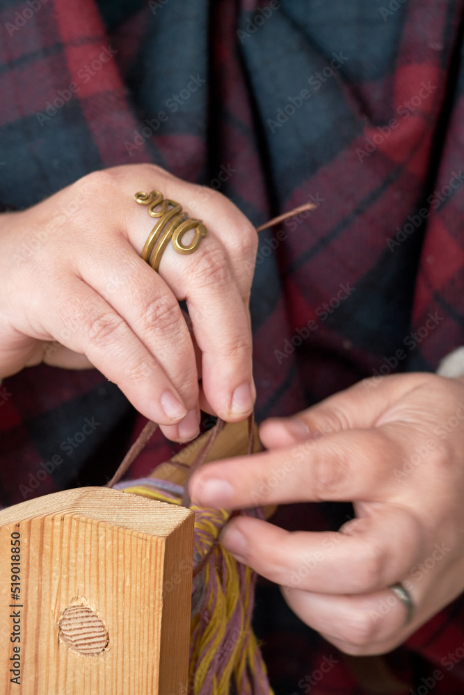 Obraz premium An ancient Roman woman makes yarn and sews from vintage wool. Reconstruction of the events of the Roman Empire