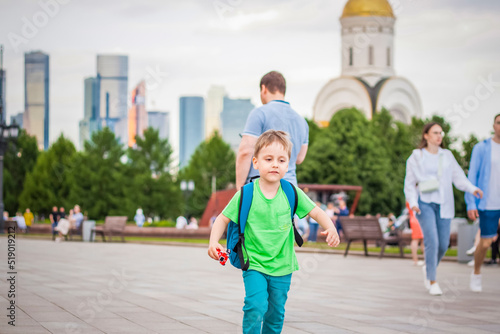 Portrait of a child, a boy against the backdrop of urban landscapes of skyscrapers and high-rise buildings in the open air. Children, Travel. Lifestyle in the city. Center, streets. © Alina Lebed