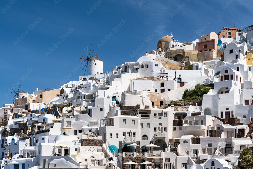 Scenic view of Oia with its typical windmill and white house. Oia is a top destination for honeymoon and romantica vacations, Santorini, Greece