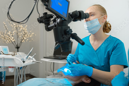 Female dentist using dental microscope