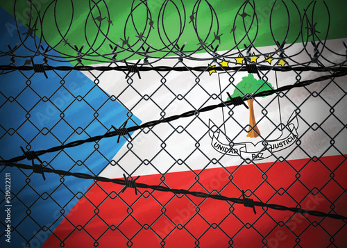 Equatorial Guinea flag behind barbed wire and metal fence