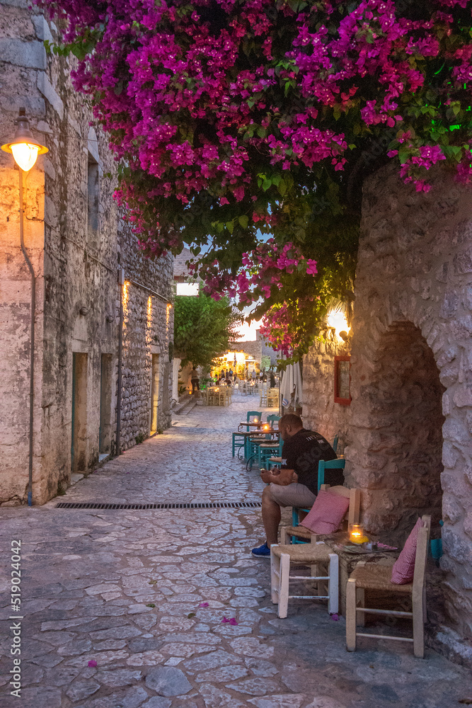 Beautiful decorated streets of Areopoli town with colorful flowers around the traditional stoned buildings in Laconia, Greece