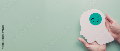 hands holding smile face in brain paper cutout, happy hormones, brain chemicals, positive mental health concept