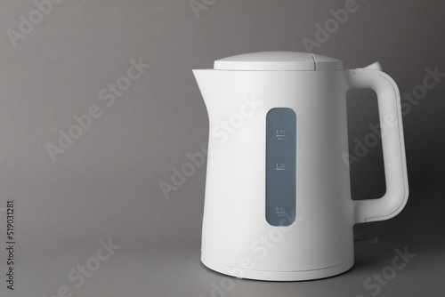 New modern electric kettle on grey background, space for text