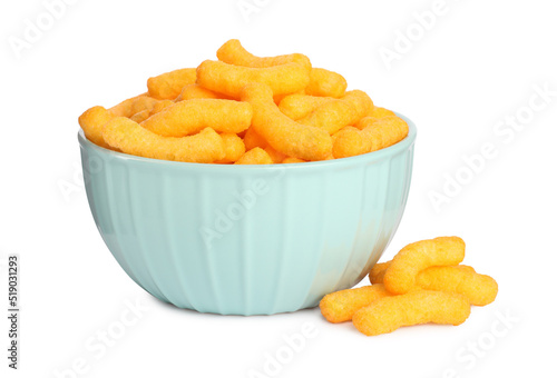 Many tasty cheesy corn puffs in bowl isolated on white