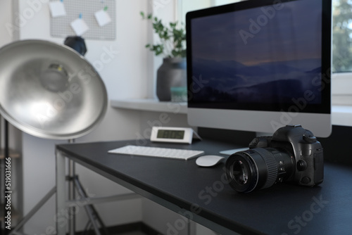 Professional camera and computer on table in photo studio. Interior design