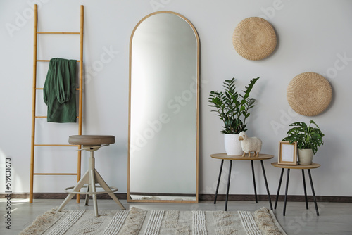 Stylish room interior with leaning floor mirror
