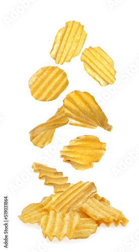 Ridged crispy potato chips falling into heap on white background