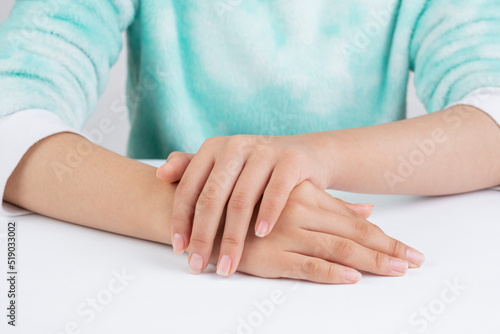 Teenager hands referring to hand care, on a table