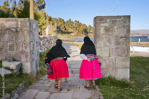 Indigenous women (Cholita) walking to the Titicaca lake photo
