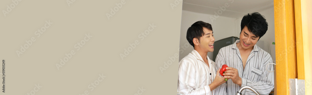 Banner Asian two Man hands wash cleaning fresh vegetable in kitchen. Panorama Happy Asian LGBTQIA gay couple homosexual cooking together in kitchen. Men wash vegetable salad home cook with copy space