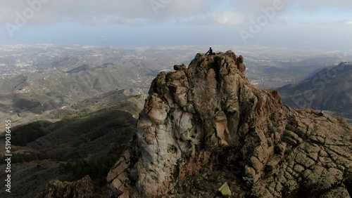 drone shot of the Roque Saucillo, a man is on the top looking at the horizon. In the city of La Vega de San Mateo, Gran Canaria island, Spain. photo