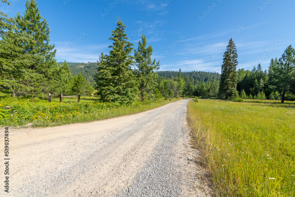 A long gravel road through the North Idaho panhandle mountains of Spirit Lake, Idaho, in the Bonner County, on a summer day.