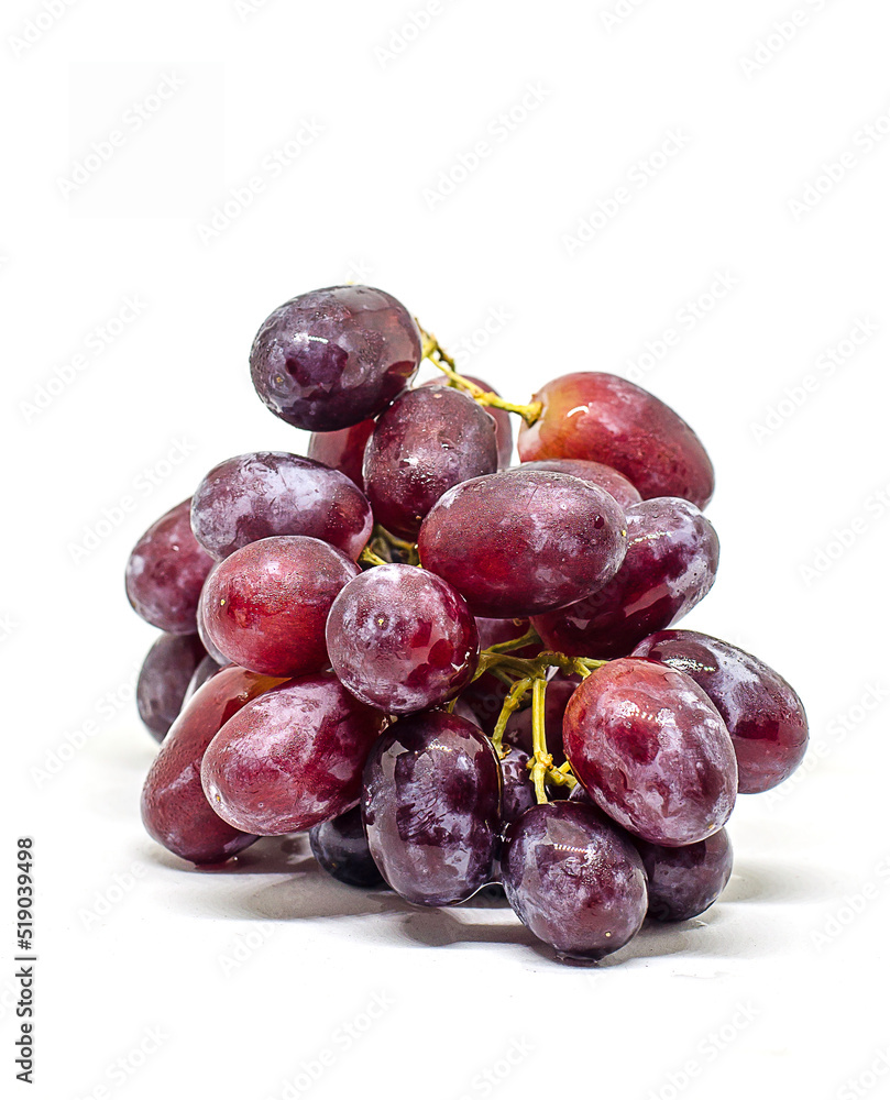 Purple fresh and wet grapes on white background