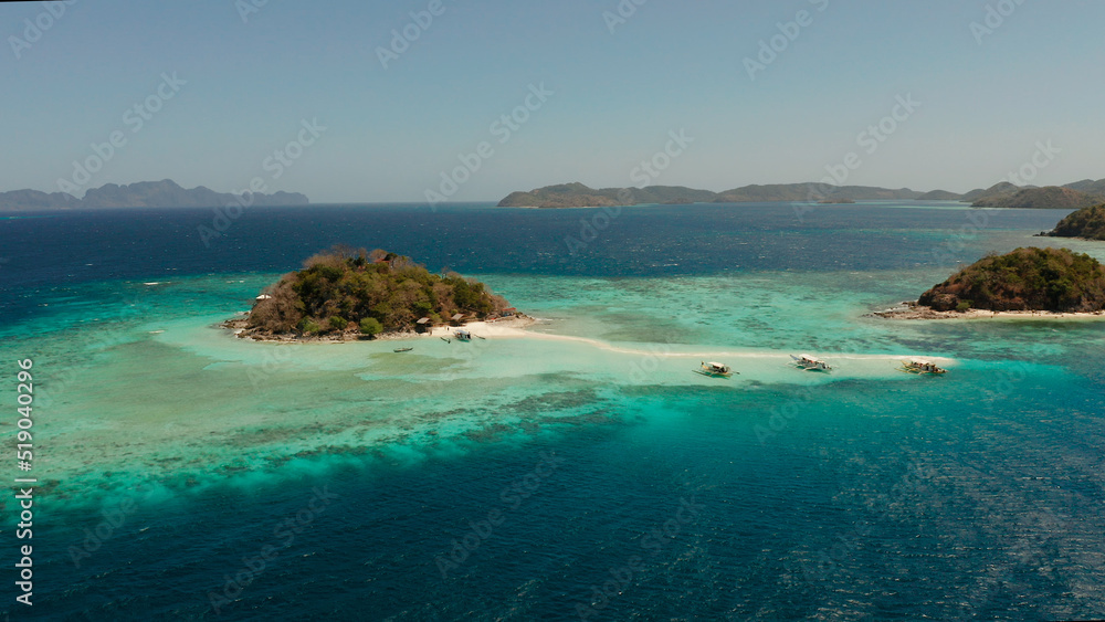 Aerial drone tourists enjoy tropical beach. tropical island and sand beach, turquoise water and coral reef. malacory island, Philippines, Palawan. tourist boats on coast tropical island.