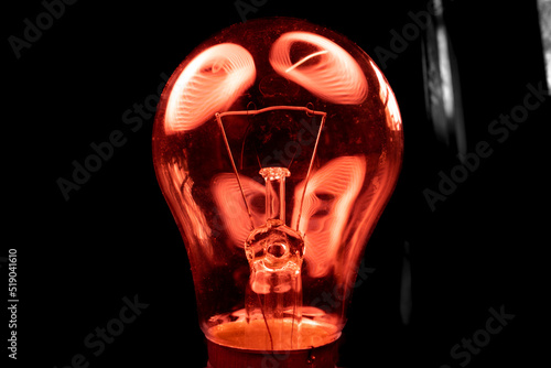 Light bulb close-up in the dark in red highlights photo