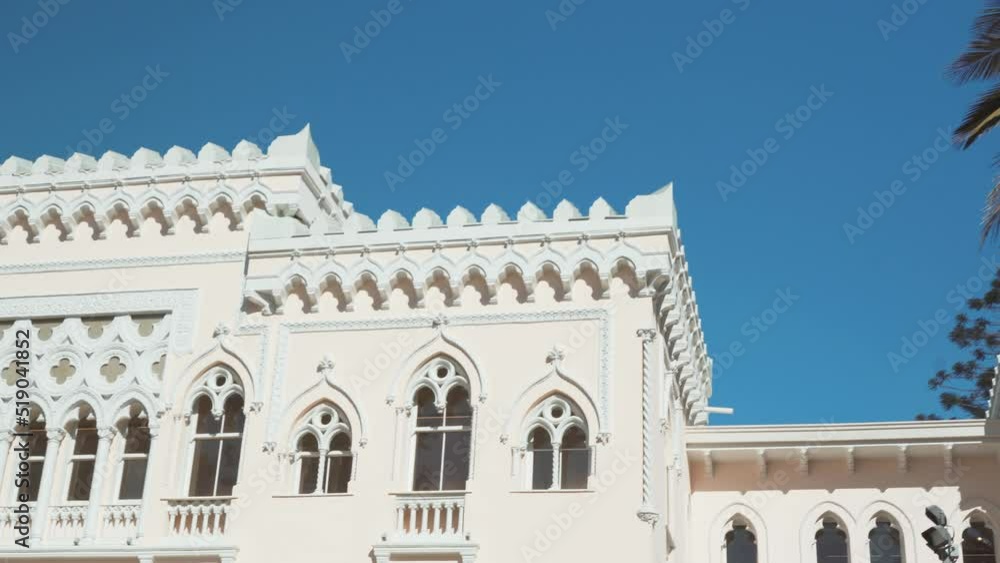 Palm Tree In Front Of Palacio Vergara Museum In Venetian Neo-Gothic Style. Quinta Vergara Park In Vina del Mar, Valparaiso, Chile. pan left, reveal Palm Tree In Front Of Palacio Vergara Museum In Venetian Neo-Gothic Style. Quinta Vergara Park In Vina del Mar, Valparaiso, Chile. pan left, reveal