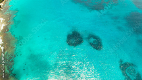 Sea water surface in lagoon with coral reef copy space for text, aerial view. Top view transparent turquoise ocean water surface. background texture
