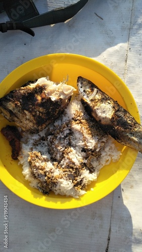 fish on the grill. Simple menu for breakfast in Indonesia, rice with grilled fish with ketchup