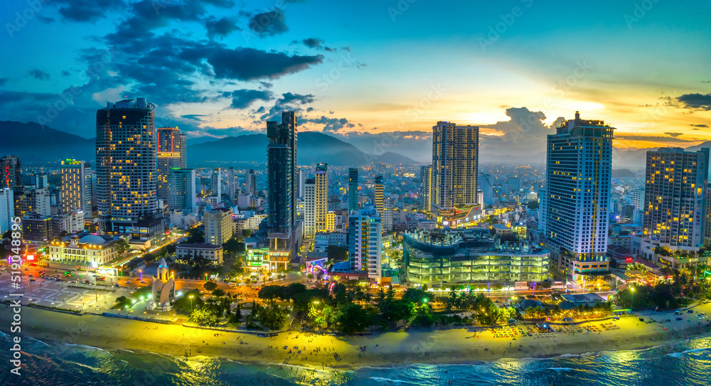 Naklejka premium The coastal city of Nha Trang, Vietnam seen from above in the afternoon with its beautiful city and clean sandy beach attracts tourists to visit