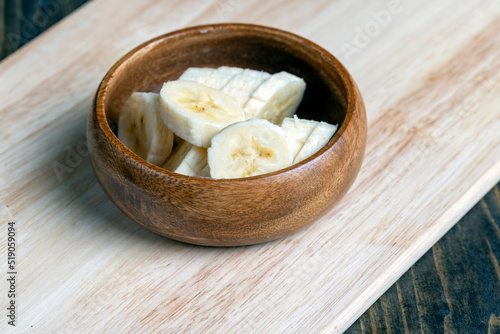 sliced ripe banana on a wooden board, close up