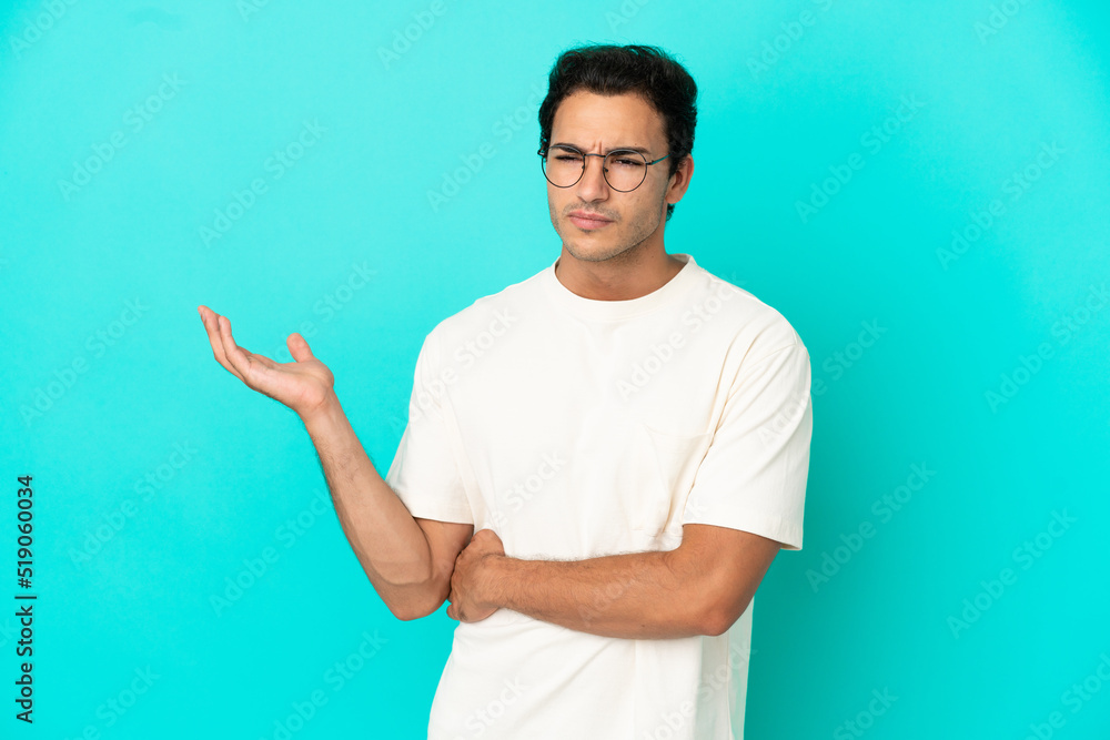 Caucasian handsome man over isolated blue background having doubts Caucasian handsome man over isolated blue background having doubts