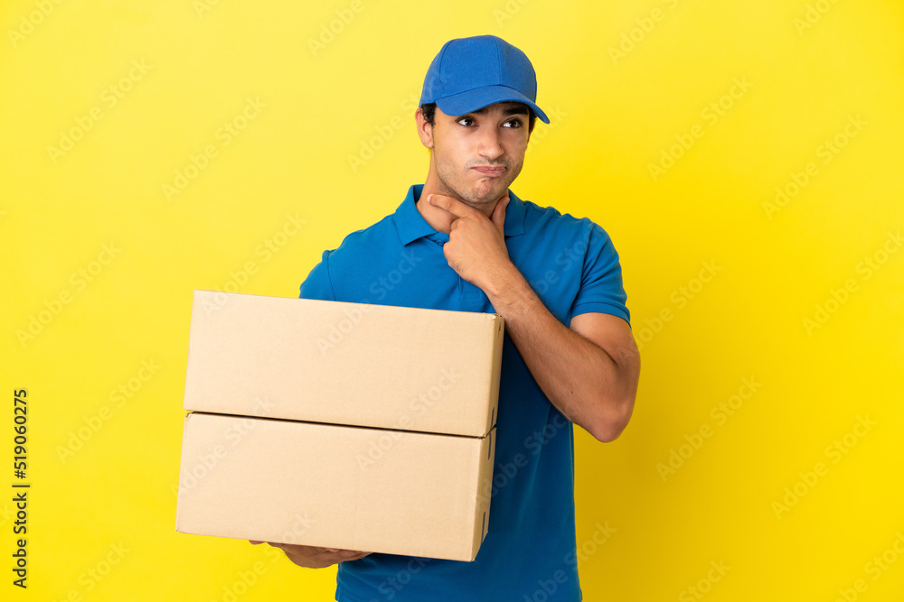 Delivery man over isolated yellow wall having doubts and thinking Delivery man over isolated yellow wall having doubts and thinking