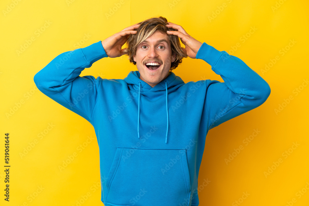 Handsome blonde man isolated on yellow background with surprise expression Handsome blonde man isolated on yellow background with surprise expression
