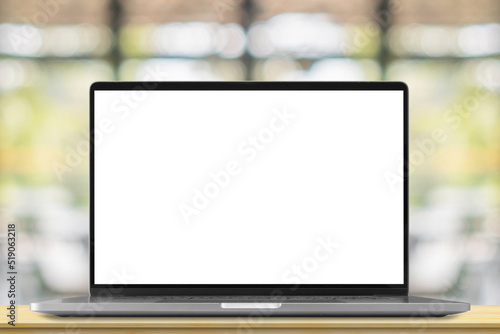 Laptop with blank screen on wood table with cafe coffee shop blur background