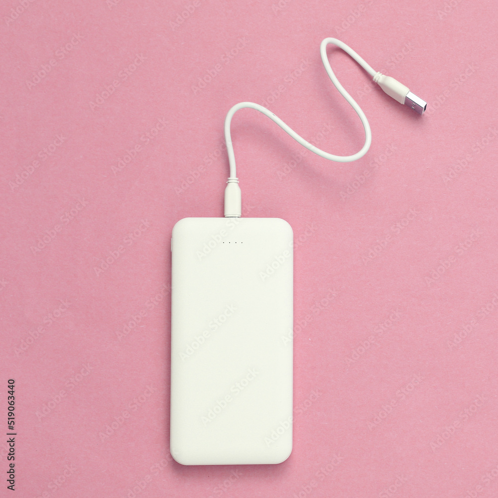 External portable battery (power bank) on pink pastel background. Top view. Flat lay. Copy space External portable battery (power bank) on pink pastel background. Top view. Flat lay. Copy space