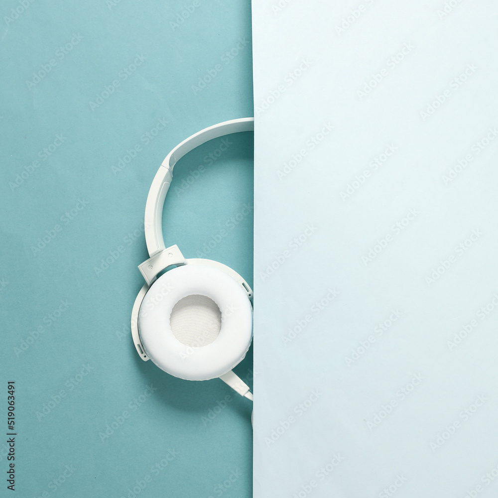 Half of the headphones on blue background. Minimalistic shot Half of the headphones on blue background. Minimalistic shot