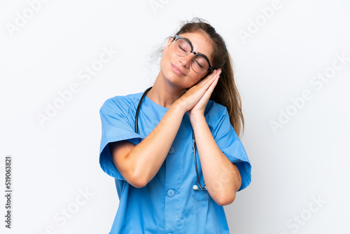 Young nurse doctor woman isolated on white background making sleep gesture in dorable expression