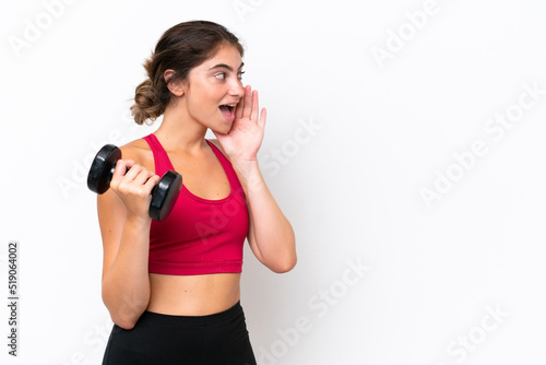 Young sport caucasian woman making weightlifting isolated on white background shouting with mouth wide open to the side