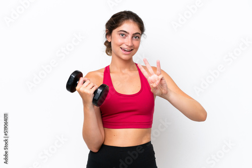 Young sport caucasian woman making weightlifting isolated on white background happy and counting three with fingers