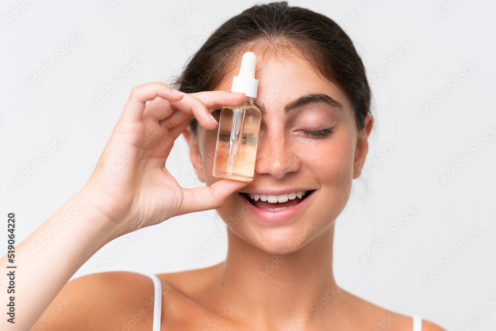 Young Pretty caucasian woman isolated on white background holding a serum while smiling. Close up portrait Young Pretty caucasian woman isolated on white background holding a serum while smiling. Close up portrait