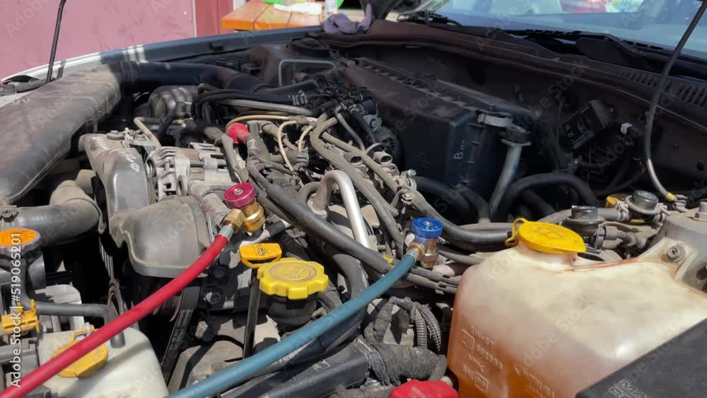 Refilling refrigerant in car with red and green tubes for air conditioning Refilling refrigerant in car with red and green tubes for air conditioning