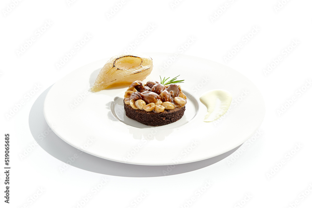 Chocolate tartlet with nuts toffee on white plate. Delicious dessert - Caramel nut tart with pear. Traditional pastry - Butterscotch tartlet with hazelnut, almond and pecan. Autumn dessert