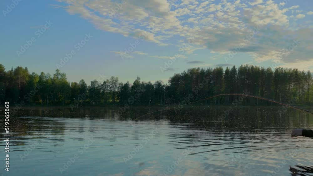 At sunset in the lake, a man is fly-fishing in the river. At sunset in the lake, a man is fly-fishing in the river.