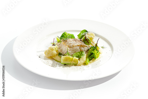 Roasted cod with mashed potatoes and broccoli. White fish fillet with skin with vegetables isolated on white background. Healthy food in restaurant menu. Fish and cabbages in minimalism style.