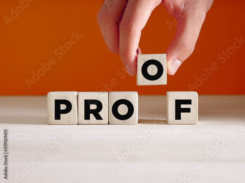 Hand puts the wooden cube with the word proof. To find a proof, evidence, verifying or proving something