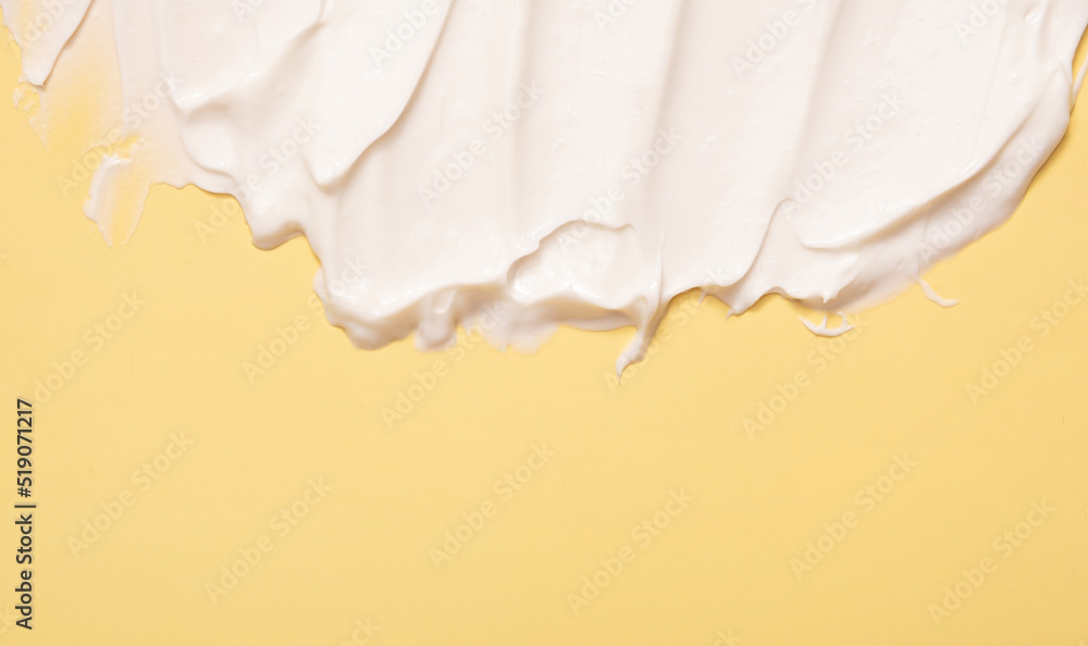 Fototapeta premium Close-up cream moisturiser smear smudge wavy texture on colored background with copy space horizontal format. Skin care beauty product