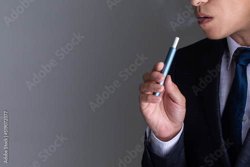 電子タバコを吸うスーツの男性　smoking photo